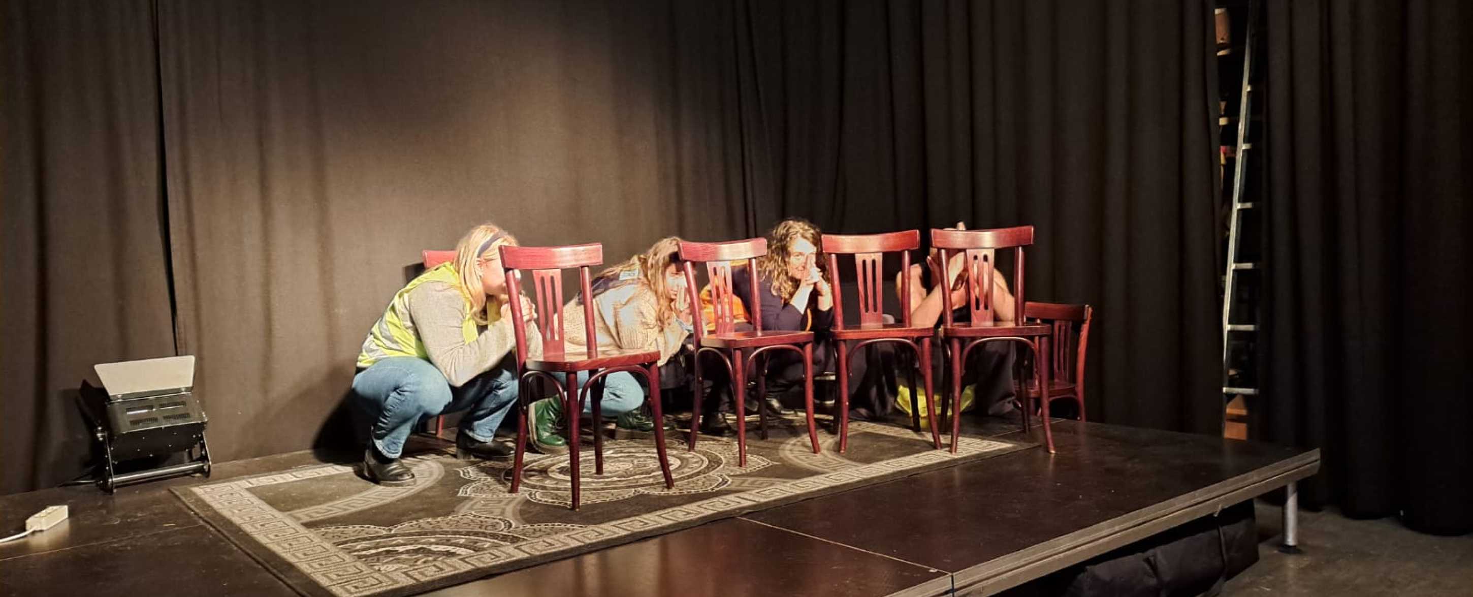 Studierende hinter Sesseln versteckt