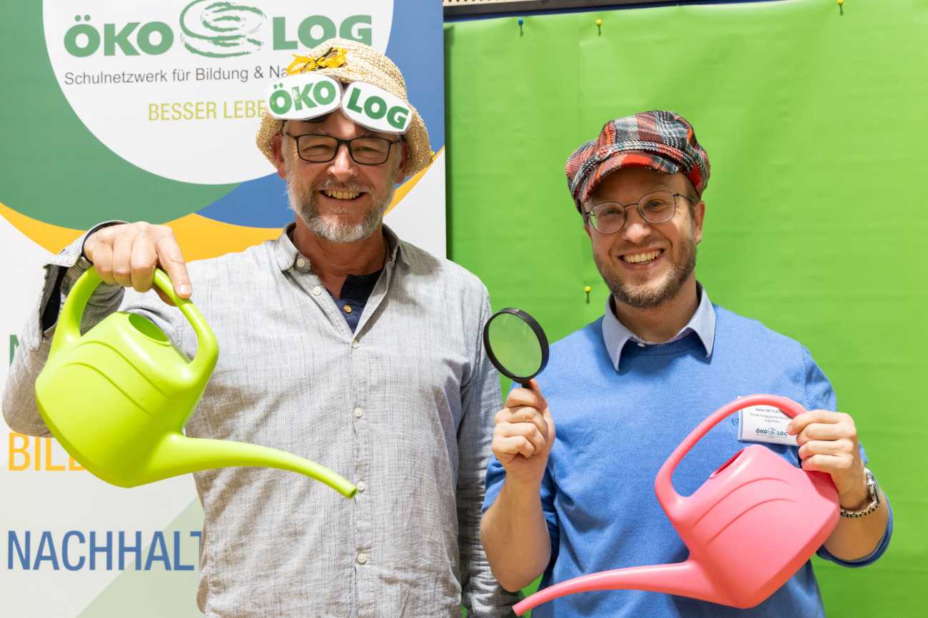 2 Herren mit Gießkanne und Lupe