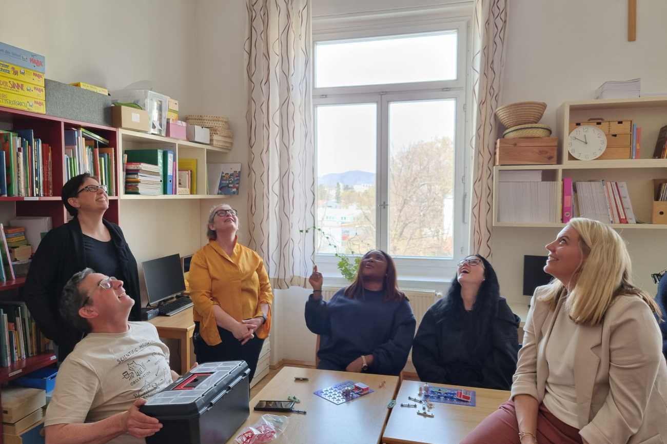 Lehrendengruppe beim Forschen nahc oben blickend