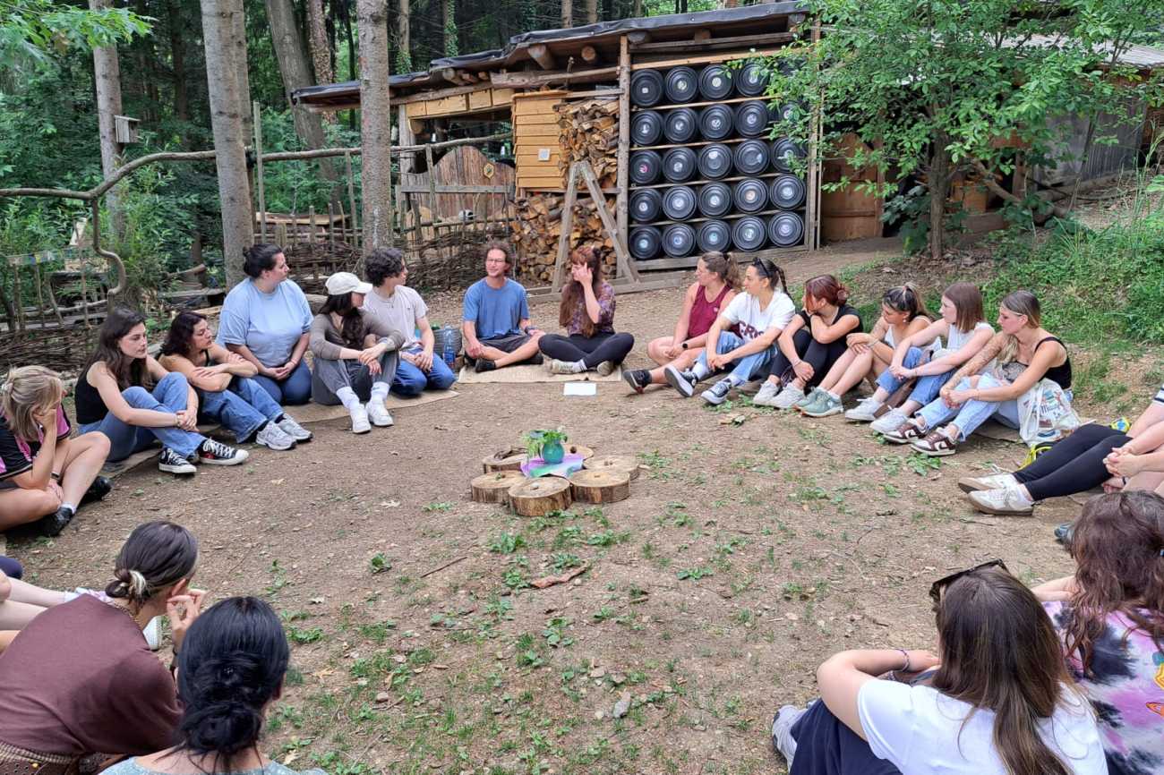 Studierendengruppe mit Anleitenden im Wald